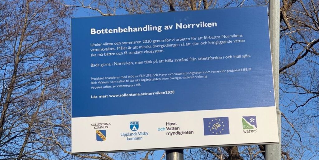 En informationsskylt om bottenbehandlingen av Norrviken,